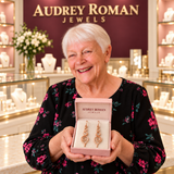 Eleanor Swirl Earrings presented in its rose box by a white-haired woman in the boutique.