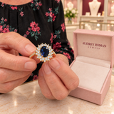 Rebecca Ring (gold-tone) held in the woman's hands for a close detail view inside the Audrey boutique.