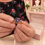 Harriet Ring (rose-gold-tone) held in the woman's hands for a close detail view inside the Audrey boutique.