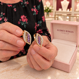Imogen Earrings (rose-gold-tone) held in the woman's hands for a close detail view inside the Audrey boutique.