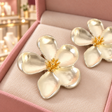 Close-up of Cassandra silver-tone flower earrings showing their petal detail in the Audrey box inside the boutique.